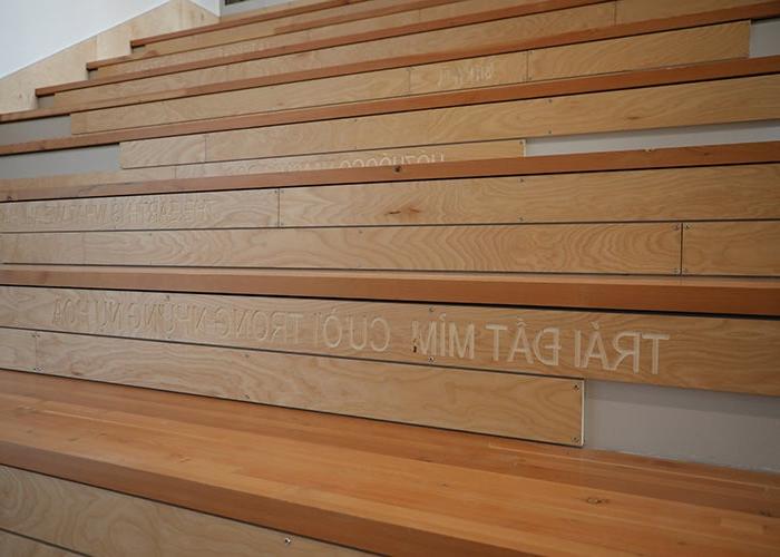 a wooden stair designed for sitting has words in several languages on the risers