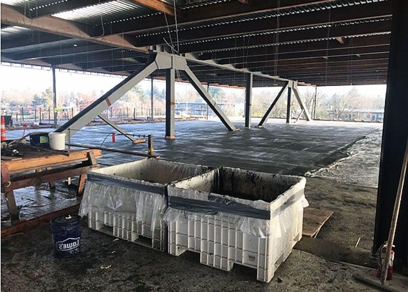 a concrete floor with steel framing and a view out the side showing it is up high